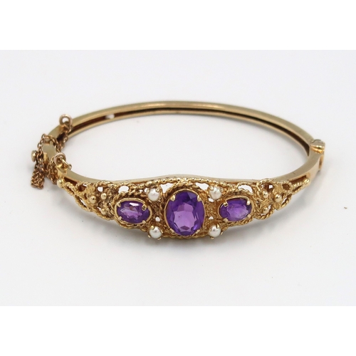 104 - A 9ct yellow gold amethyst and seed pearl bangle, approx 15.38 grams