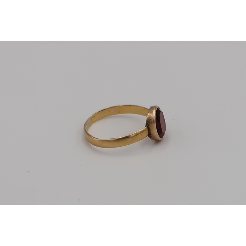 11 - A 22ct yellow gold ring with oval cut garnet to shoulder - weight approx 1.94 grams - ring size N