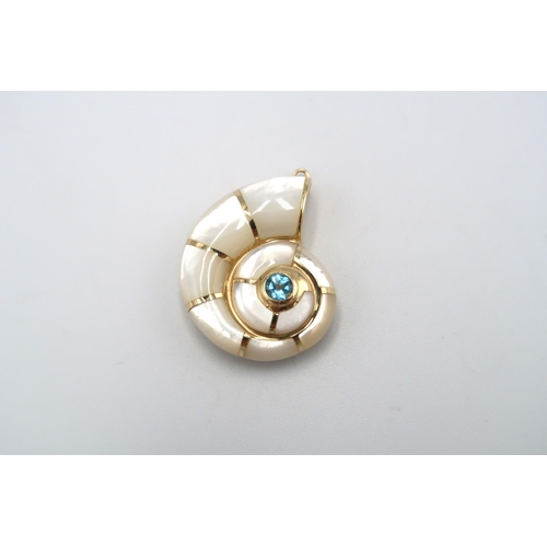 113 - A pendant in the form of a mother of pearl conch shell with central blue stone. Length 30mm. Tests g... 