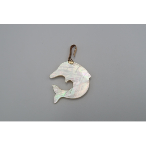 117 - A mother of pearl dolphin pendant with a blue stone collet eye. Length 38mm. Hook surmount stamped 3... 