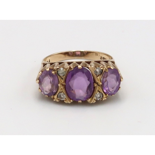 142 - A 9ct gold three stone ring set with amethysts - ring size N - weight approx 3.84 grams