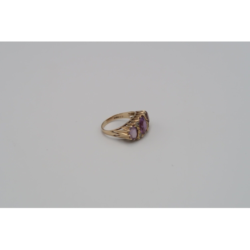 142 - A 9ct gold three stone ring set with amethysts - ring size N - weight approx 3.84 grams