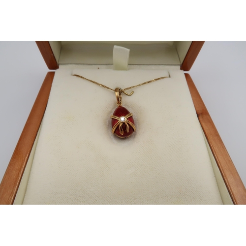 26 - A Faberge egg pendant decorated in 18ct yellow gold with red enamel, diamond to centre of bow with s... 