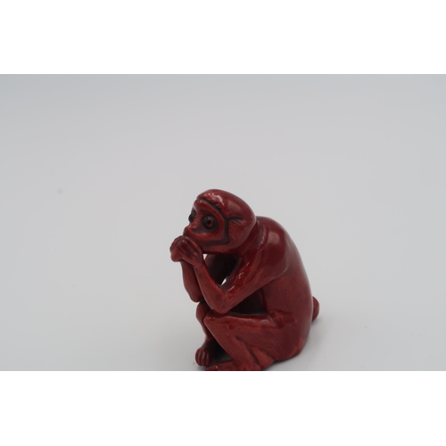 474 - A Bernard Moore mottled flambe model of a seated monkey eating a nut, 7.5 cm high