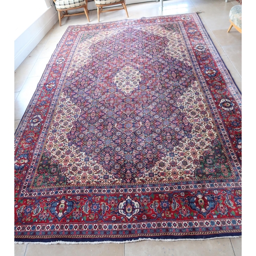 581 - A Sarouk Persian rug, 333cm x 214cm, blue ground central floral field surrounded by geometric border... 