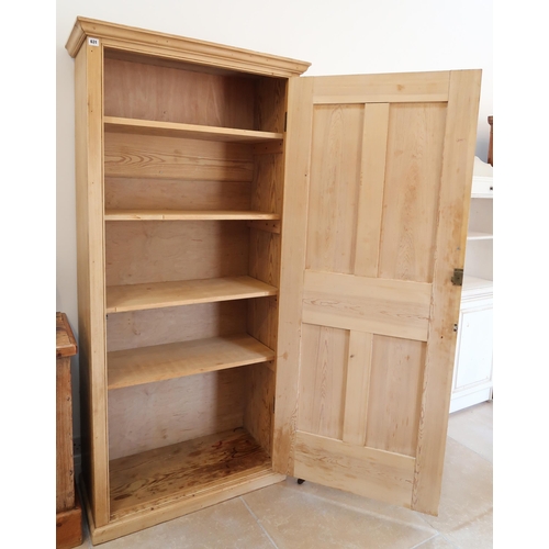 631 - A Pine cupboard with single door opening to reveal shelves, raised on plinth. 87cm wide x 37cm deep ... 