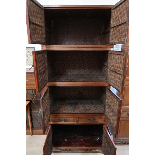 635 - A Chinese hardwood modular cabinet of four sections, each section with two doors, bottom section wit... 