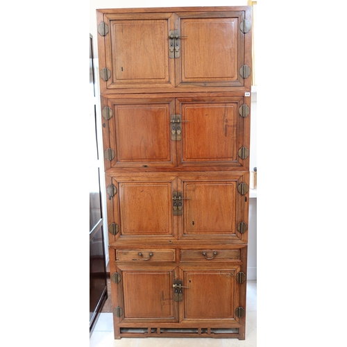 636 - A Chinese hardwood modular cabinet of four sections, each with two doors, the bottom section with tw... 