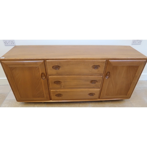 651 - An Ercol mid 20th Century blonde elm sideboard, three central drawers flanked by doors, top drawer w... 