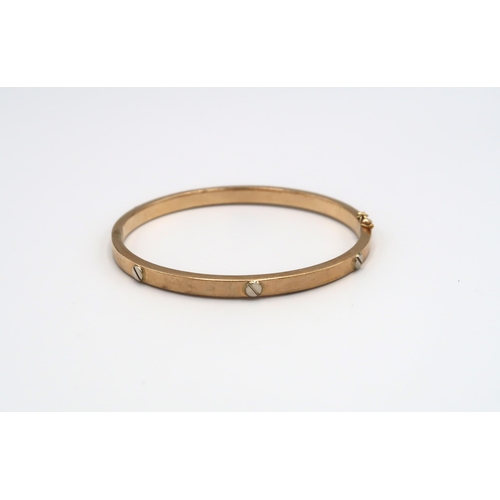 71 - A 9ct yellow gold bangle with flathead screw decoration, approx 10.99 grams