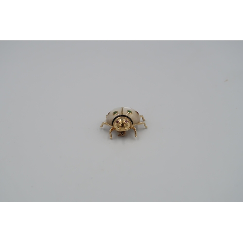 120 - A mother of pearl ladybird brooch with stone collets and black enamel detail. Stamped 14K. Length 27... 