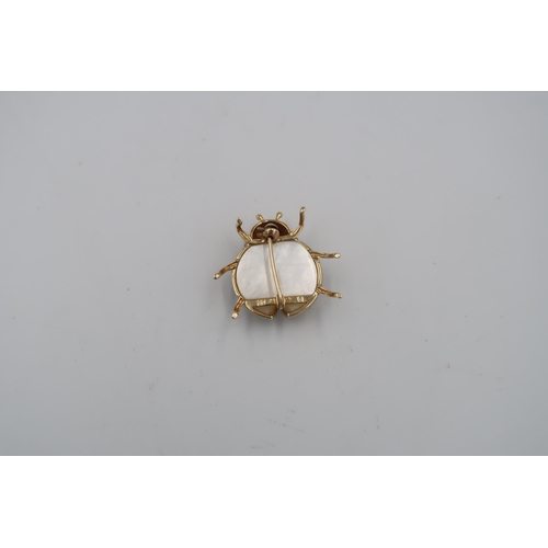 120 - A mother of pearl ladybird brooch with stone collets and black enamel detail. Stamped 14K. Length 27... 