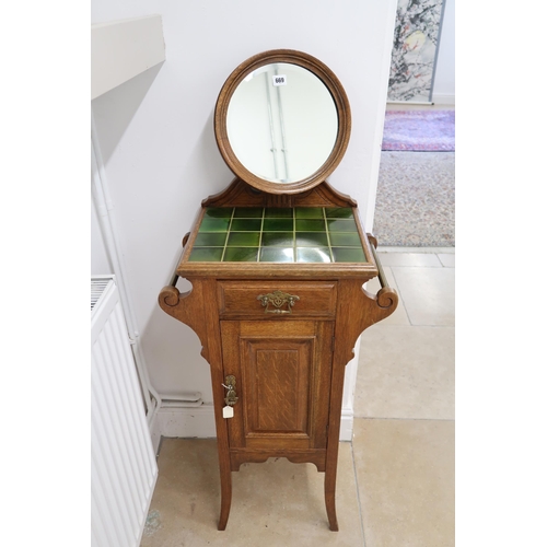 669 - A Victorian oak Tile top washstand or shaving stand, Circular mirror over drawer above door.