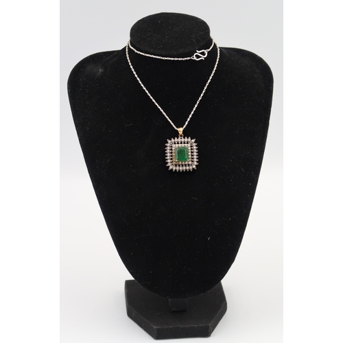 13 - A brilliant cut diamond and emerald square cluster pendant. Width 23mm. Tests silver and gold. Suspe... 