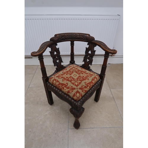 621 - An oak corner chair with carved decoration and drop in seat.