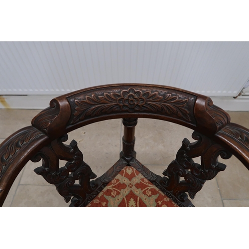 621 - An oak corner chair with carved decoration and drop in seat.