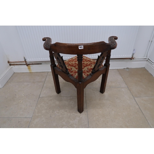 621 - An oak corner chair with carved decoration and drop in seat.