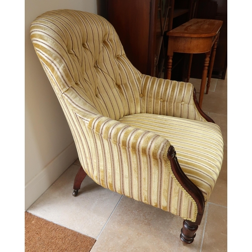 A Victorian mahogany framed button back armchair raised on turned supports.