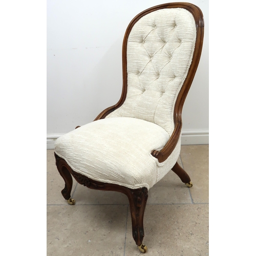 624 - A walnut framed spoon back nursing chair, button upholstery in white raised on casters.