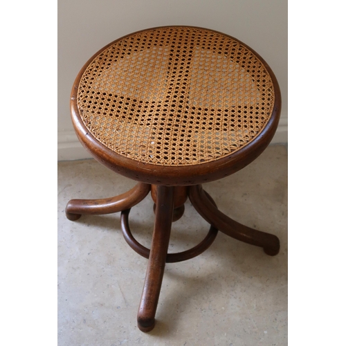 629 - A circular bentwood adjustable cane seated stool. adjusting from a height of 46cm to 66cm. raised on... 