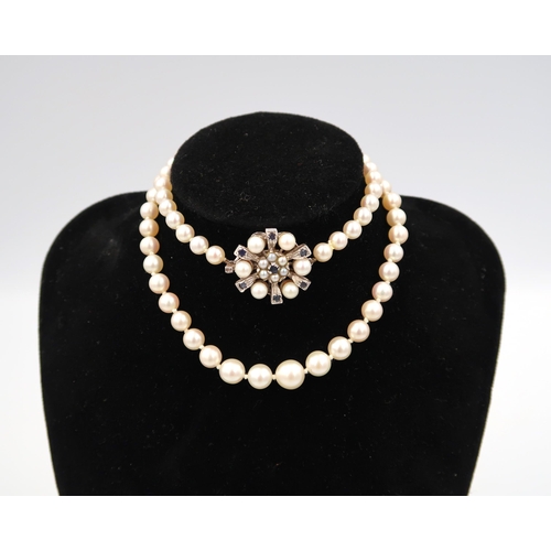 188 - A pearl necklace with a 9ct white gold sapphire and pearl clasp - head size approx 21mm - approx len... 