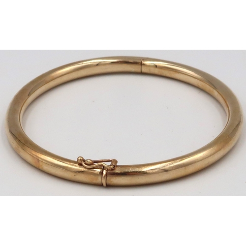 10 - A 9ct gold hinged bangle. Weight 11.89 grams