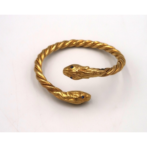 2 - A rope twist crossover torc style bangle with snake head terminations, tests gold 18ct, metal core, ... 