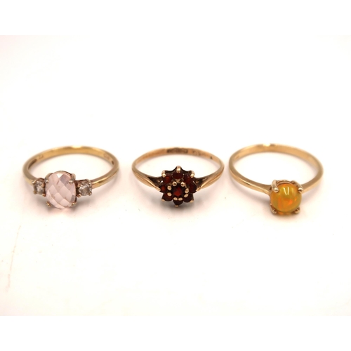 29 - A 9ct yellow gold and fire opal cabochon ring Size P, a 9ct gold crucifix, a 9ct gold garnet cluster... 