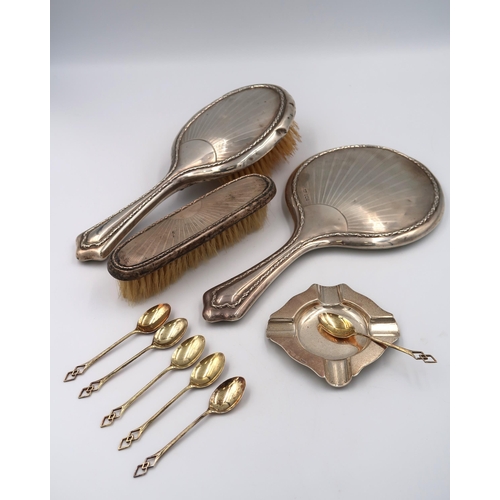 337 - A hallmarked silver ashtray, six silver gilt teaspoons, silver hallmarked hand mirror, clothes brush... 