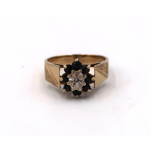 43 - A hallmarked 9ct yellow gold cluster ring with illusion set diamond to centre surrounded by sapphire... 