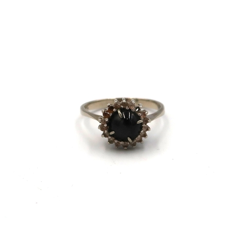 5 - A black gem cabochon  displaying asterism - optic star- and white stone cluster (2 stones missing), ... 