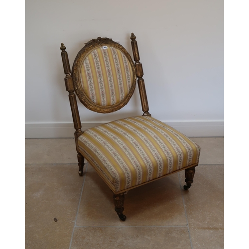 631 - A French Louis XV style giltwood nursing chair with striped upholstery to back and seat raised on sh... 