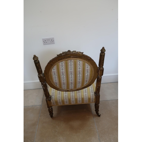 631 - A French Louis XV style giltwood nursing chair with striped upholstery to back and seat raised on sh... 