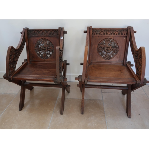 637 - A pair of oak Glastonbury hall chairs, heavily carved with cross frame to seat joined by stretcher, ... 