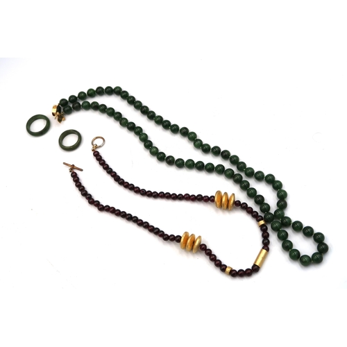 89 - A nephrite jade bead necklace and two band rings, Size P and L, together with a red bead necklace.