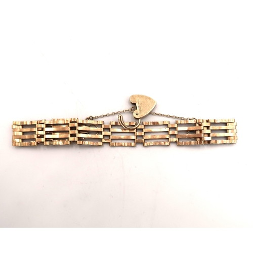 93 - A hallmarked 9ct gold heart shaped locket on a curb link bracelet - tests as 9ct yellow gold, approx... 