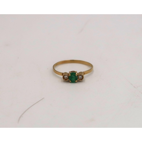 96 - A stamped 750 18ct yellow gold dress ring with central emerald flanked by two small diamonds, size M... 