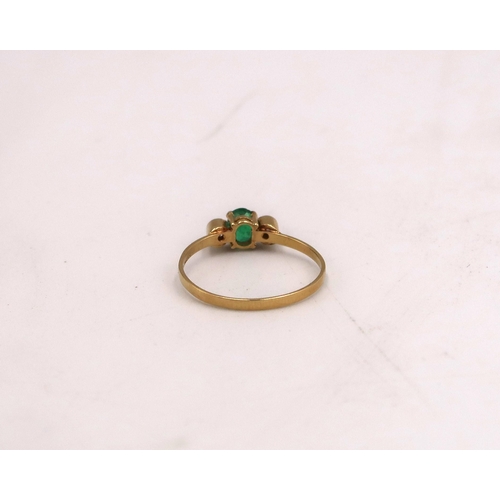 96 - A stamped 750 18ct yellow gold dress ring with central emerald flanked by two small diamonds, size M... 