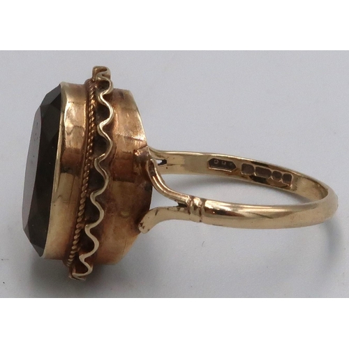 16 - A 9ct marked yellow gold dress ring with oval Smokey Quartz to shoulder, 3.7grams, Size M/N