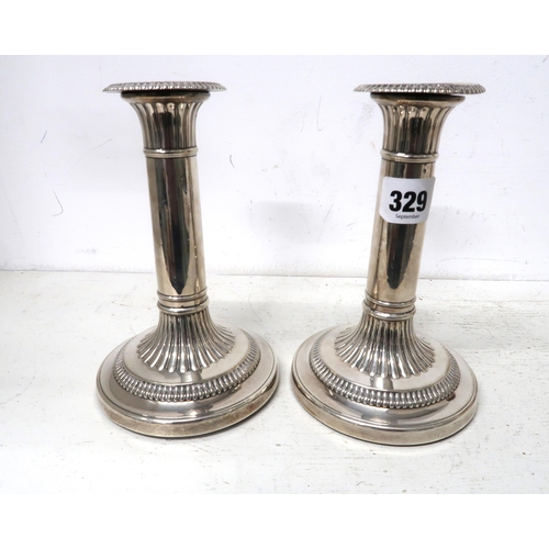 329 - A pair of silver H.M. Georgian candlesticks with fluted decoration 11cm dia. at base 17cm high 6cm d... 