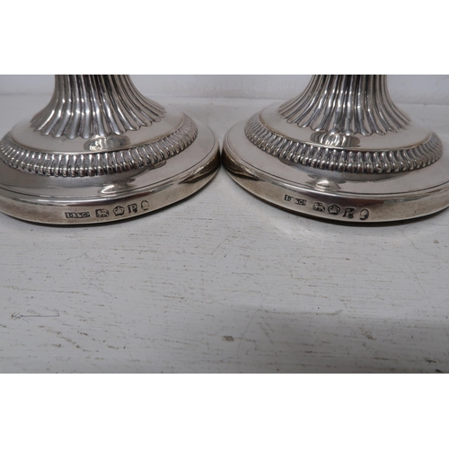 329 - A pair of silver H.M. Georgian candlesticks with fluted decoration 11cm dia. at base 17cm high 6cm d... 