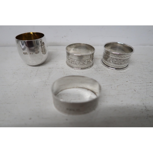 359 - Three silver napkin rings and a silver gilt egg cup - approx total weight 2.8 troy oz