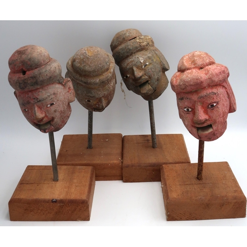 445 - Four antique carved wooden heads, Burmese Indo-Chino with articulated mouths on stands, 23cm high, C... 