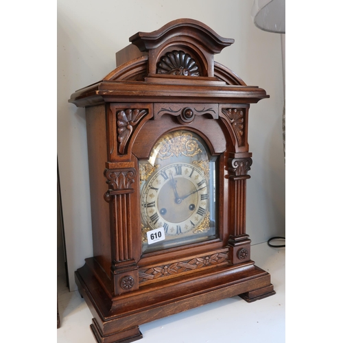 610 - An 8 day oak striking mantle clock in a walnut case - Height 47cm - has key and pendulum, case in go... 