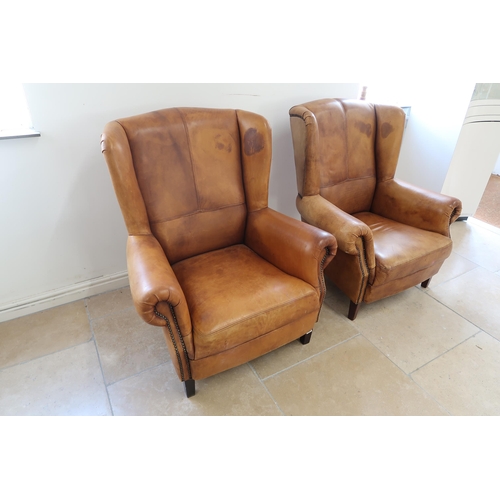 664 - Two brown leather upholstered wingback armchairs with distressed finish - in good condition - Height... 