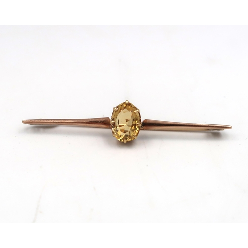 220 - An oval citrine bar brooch. Stamped 15. Weight 3.89 grams.