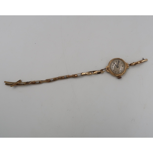 284 - A ladies 9ct hallmarked yellow gold wristwatch on 9ct marked gold bracelet strap - silvered dial wit... 