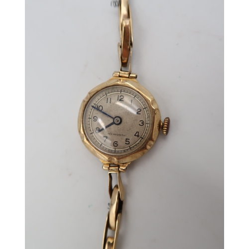 284 - A ladies 9ct hallmarked yellow gold wristwatch on 9ct marked gold bracelet strap - silvered dial wit... 