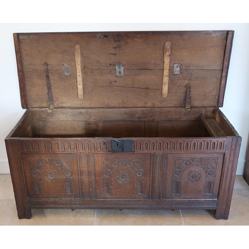 705 - An antique oak coffer - Three carved panels to front lift top opening to reveal candle box raised on... 