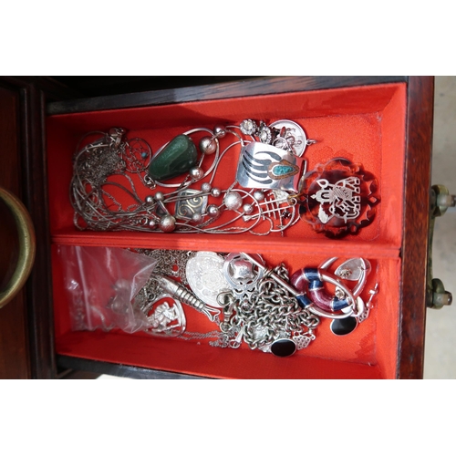 174 - A jewellery cabinet of eight drawers containing various silver and costume jewellery - items include... 